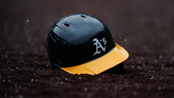 Apr 4, 2025; Denver, Colorado, USA; An Athletics helmet sits in the dirt after being thrown in the tenth inning against the Colorado Rockies at Coors Field. Mandatory Credit: Isaiah J. Downing-Imagn Images