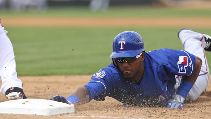 March 25, 2012; Surprise, AZ, USA; Texas Rangers center fielder Julio Borbon (20) dives back into first base on a pick off attempt against the Los Angeles Angels at the Tempe Diablo Stadium.
