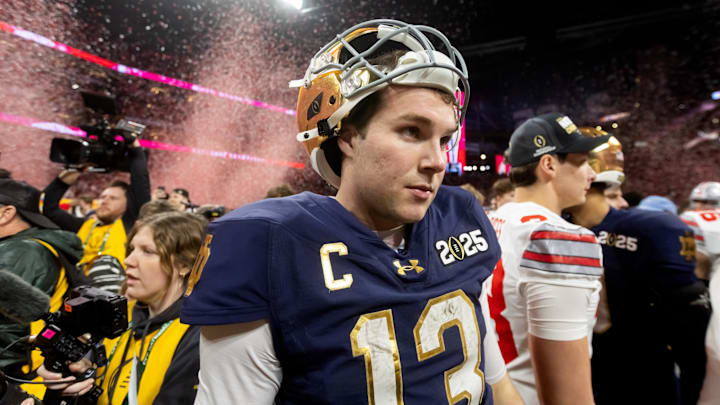 Jan 20, 2025; Atlanta, GA, USA; Confetti falls as Notre Dame Fighting Irish quarterback Riley Leonard (13) walks off the field after losing to the Ohio State Buckeyes in the CFP National Championship college football game at Mercedes-Benz Stadium. Jan 20, 2025; Atlanta, GA, USA; Confetti falls as Notre Dame Fighting Irish quarterback Riley Leonard (13) walks off the field after losing to the Ohio State Buckeyes in the CFP National Championship college football game at Mercedes-Benz Stadium.