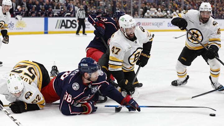 Mar 29, 2026; Columbus, Ohio, USA; Columbus Blue Jackets center Boone Jenner (38) reaches for the loose puck with Boston Bruins center Mark Kastelic (47) during the second period at Nationwide Arena. Mandatory Credit: Russell LaBounty-Imagn Images
