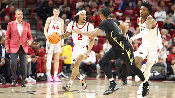 Dec 30, 2024; Fayetteville, Arkansas, USA; Arkansas Razorbacks guard Boogie Fland (2) dribbles during the first half as head coach John Calipari and forward Karter Knox (11) look on against the Oakland Golden Grizzlies at Bud Walton Arena. Mandatory Credit: Nelson Chenault-Imagn Images
