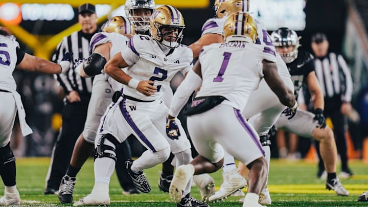 Demond Williams turns and hands the ball to Jonah Coleman at Oregon.