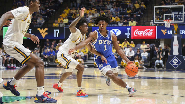 Feb 28, 2026; Morgantown, West Virginia, USA; BYU Cougars guard Robert Wright III (1) drives against West Virginia Mountaineers guard Honor Huff (3) during the first half at Hope Coliseum. Mandatory Credit: Ben Queen-Imagn Images