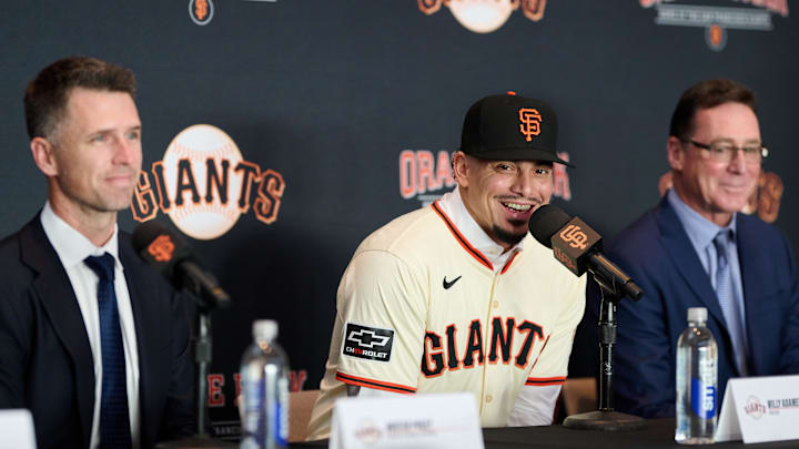 Dec 12, 2024; San Francisco, CA, USA; San Francisco Giants shortstop Willy Adames reacts during his introductory press conference with president of baseball operations Buster Posey (left) and manager Bob Melvin (right) at Oracle Park.  