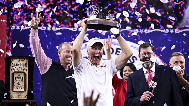 Dec 27, 2025; Houston, TX, USA; Houston Cougars head coach Willie Fritz hoists the champions trophy after the win over Louisiana State Tigers at NRG Stadium. Mandatory Credit: Maria Lysaker-Imagn Images Dec 27, 2025; Houston, TX, USA; Houston Cougars head coach Willie Fritz hoists the champions trophy after the win over Louisiana State Tigers at NRG Stadium. Mandatory Credit: Maria Lysaker-Imagn Images