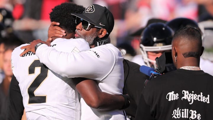 Colorado football coach Deion Sanders hugs his son, Shedeur Sanders, before facing Texas Tech.