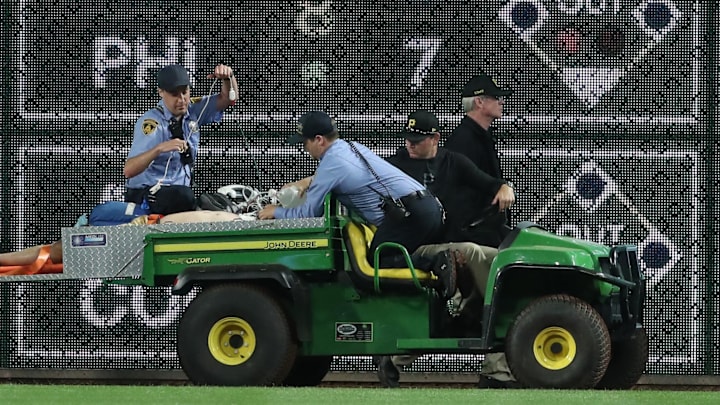 Apr 30, 2025; Pittsburgh, Pennsylvania, USA;  Stadium security and Pittsburgh Pirates medical personnel cart a fan who fell from the stands to the field to an ambulance as the Pirates batted against the Chicago Cubs during the seventh inningat PNC Park. Mandatory Credit: Charles LeClaire-Imagn Images