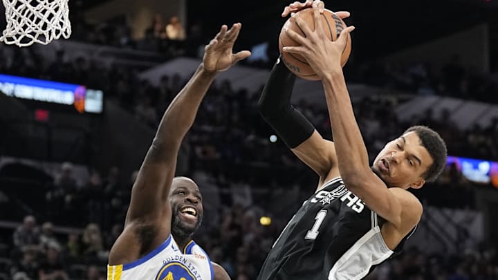 San Antonio Spurs forward Victor Wembanyama (1) grabs a rebound away from Golden State Warriors forward Draymond Green (23) during the first half at Frost Bank Center. Mandatory Credit: Scott Wachter-Imagn Images