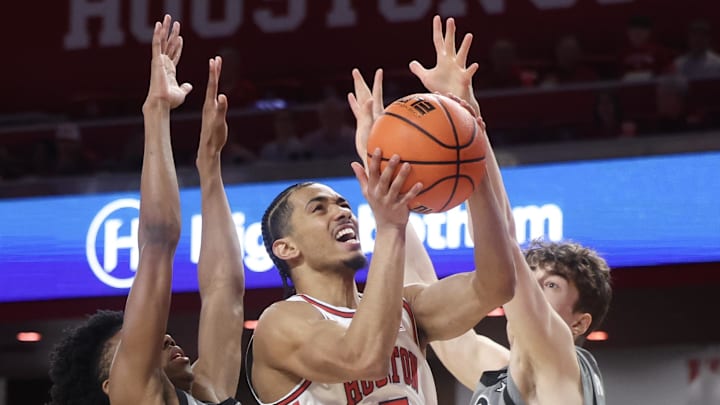 Feb 28, 2026; Houston, Texas, USA;  Houston Cougars guard Milos Uzan (7) splits the defense of Colorado Buffaloes guard Isaiah Johnson (2) and forward Sebastian Rancik (7) in the first half at Fertitta Center. Mandatory Credit: Thomas Shea-Imagn Images
