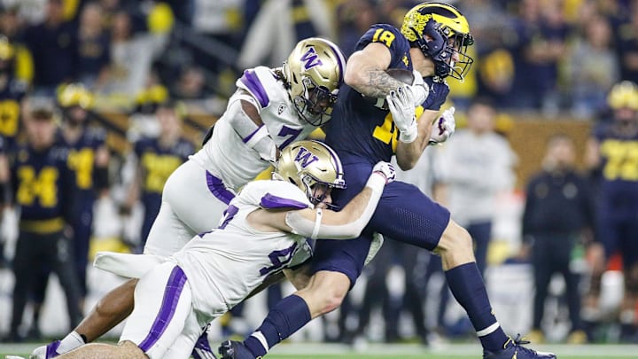 Michigan tight end Colston Loveland (18) makes a catch against Washington linebacker Carson Bruener (42) and cornerback Dominique Hampton (7) during the first half of the national championship game at NRG Stadium in Houston on Monday, Jan. 8, 2024.
