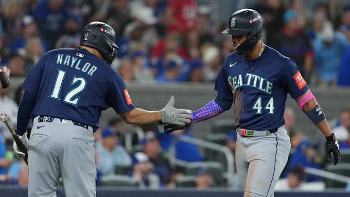 Oct 20, 2025; Toronto, Ontario, CAN; Seattle Mariners center fielder Julio Rodriguez (44) celebrates with first baseman Josh Naylor (12) after hitting a home run in the third inning against the Toronto Blue Jays during game seven of the ALCS round for the 2025 MLB playoffs at Rogers Centre. Mandatory Credit: Nick Turchiaro-Imagn Images