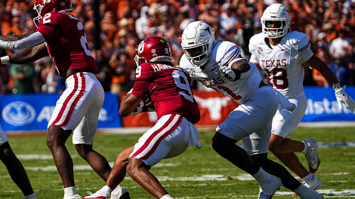 Oklahoma quarterback Michael Hawkins Jr. (9) braces for a hit by Texas Longhorns edge rusher Colin Simmons (11) during the Red River Rivalry game at the Cotton Bowl on Saturday, Oct. 12, 2024 in Dallas, Texas.