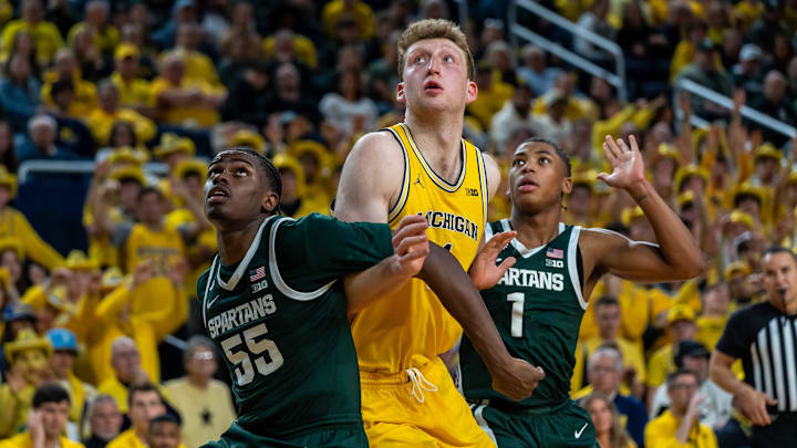 Michigan’s Danny Wolf (1) attempts to catch a rebound as Michigan State’s Coen Carr (55) and Jeremy Fears Jr. (1) box him out during the second half of their matchup at Crisler Center in Ann Arbor on Friday, Feb. 21, 2025.