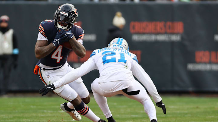 Dec 22, 2024; Chicago, Illinois, USA; Chicago Bears running back D'Andre Swift (4) rushes teh ball against Detroit Lions cornerback Amik Robertson (21) during the second half at Soldier Field. Mandatory Credit: Mike Dinovo-Imagn Images