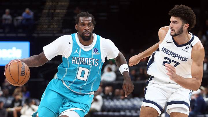 Oct 16, 2026; Memphis, Tennessee, USA;  Charlotte Hornets center Naz Reid (0) drives to the basket as Memphis Grizzlies forward Cameron Boozer (27) defends during the third quarter at FedExForum.  Mandatory Credit: Petre Thomas-Imagn Images