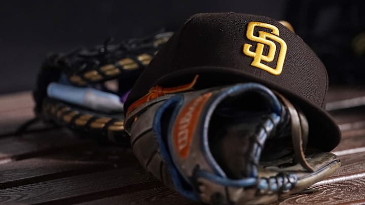 Jul 23, 2021; Miami, Florida, USA; A general view of a San Diego Padres hat and glove in the dugout prior to the game between the Miami Marlins and the San Diego Padres at loanDepot park. Mandatory Credit: Jasen Vinlove-Imagn Images Jul 23, 2021; Miami, Florida, USA; A general view of a San Diego Padres hat and glove in the dugout prior to the game between the Miami Marlins and the San Diego Padres at loanDepot park. Mandatory Credit: Jasen Vinlove-Imagn Images