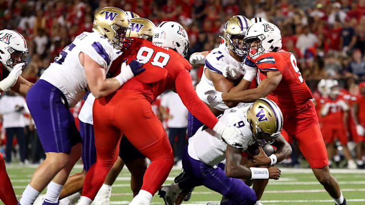 Sep 30, 2023; Tucson, Arizona, USA; Washington Huskies quarterback Michael Penix Jr. (9) runs the ball agaisnt Arizona Wildcats defensive lineman Tiaoalii Savea (98) in the second half at Arizona Stadium. Mandatory Credit: Zachary BonDurant-Imagn Images