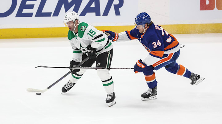 Mar 26, 2026; Elmont, New York, USA;  Dallas Stars center Colin Blackwell (15) and New York Islanders defenseman Adam Boqvist (34) battle for control of the puck in the first period at UBS Arena. Mandatory Credit: Wendell Cruz-Imagn Images