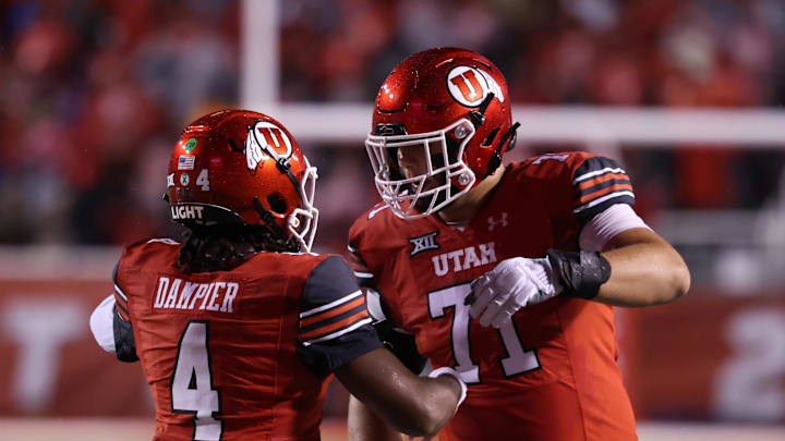 Utah Utes quarterback Devon Dampier (4) celebrates scoring a touchdown against the Arizona State Sun Devils with Utah Utes offensive lineman Caleb Lomu (71) during the second quarter at Rice-Eccles Stadium.