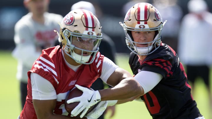 Jul 23, 2025; Santa Clara, CA, USA; San Francisco 49ers running back Isaac Guerendo (31) takes a handoff from quarterback Mac Jones (10) during the first day of training camp at SAP Performance Facility. Mandatory Credit: D. Ross Cameron-Imagn Images