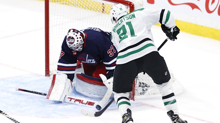 Nov 9, 2024; Winnipeg, Manitoba, CAN; Winnipeg Jets goaltender Connor Hellebuyck (37) makes a stick save on a Dallas Stars left wing Jason Robertson (21) shot in the third period at Canada Life Centre. Mandatory Credit: James Carey Lauder-Imagn Images