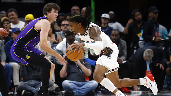 Nov 6, 2024; Memphis, Tennessee, USA; Memphis Grizzlies guard Ja Morant (12) drives to the basket around Los Angeles Lakers guard Austin Reaves (15) during the first half at FedExForum. Mandatory Credit: Petre Thomas-Imagn Images