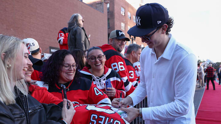 Oct 16, 2025; Newark, New Jersey, USA; New Jersey Devils defenseman Luke Hughes (43) signs an autograph for a fan before the start of the Devils home opener against the Florida Panthers at Prudential Center. Mandatory Credit: Ed Mulholland-Imagn Images Oct 16, 2025; Newark, New Jersey, USA; New Jersey Devils defenseman Luke Hughes (43) signs an autograph for a fan before the start of the Devils home opener against the Florida Panthers at Prudential Center. Mandatory Credit: Ed Mulholland-Imagn Images