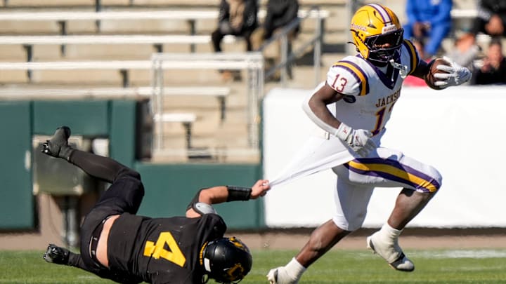 Dec 6, 2024; Birmingham, AL, USA; Cherokee County's Tristan Brown (4) tries to hang on for a tackle as Jackson's Ezavier Crowell (13) pulls away at Protective Stadium in the AHSAA 4A State Championship game.