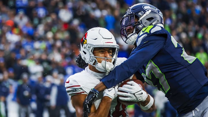 Nov 24, 2024; Seattle, Washington, USA; Arizona Cardinals wide receiver Michael Wilson (14) catches a pass against Seattle Seahawks cornerback Riq Woolen (27) during the fourth quarter at Lumen Field. Mandatory Credit: Joe Nicholson-Imagn Images