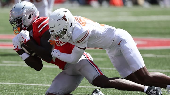 Aug 30, 2025; Columbus, Ohio, USA; Ohio State Buckeyes wide receiver Jeremiah Smith (4) makes a catch over Texas Longhorns defensive back Malik Muhammad (5) in the first half at Ohio Stadium. Mandatory Credit: Joseph Maiorana-Imagn Images