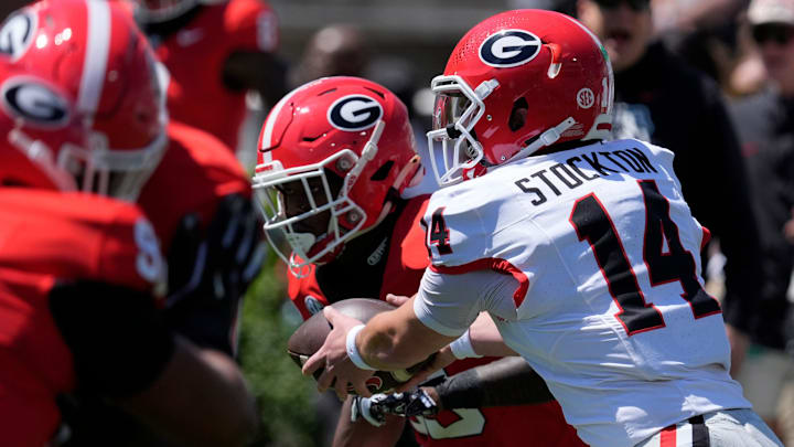 Georgia quarterback Gunner Stockton (14) hands off the ball to Georgia running back Nate Frazier (3) 