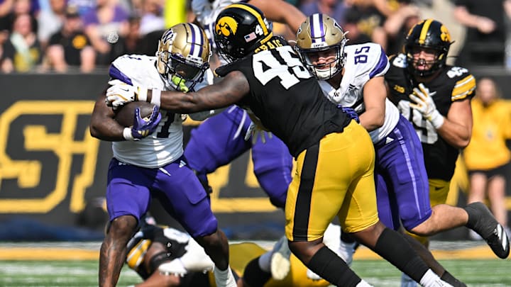 Oct 12, 2024; Iowa City, Iowa, USA; Washington Huskies running back Jonah Coleman (1) is tackled by Iowa Hawkeyes defensive lineman Deontae Craig (45) as tight end Keleki Latu (85) looks to block during the fourth quarter at Kinnick Stadium. Mandatory Credit: Jeffrey Becker-Imagn Images Oct 12, 2024; Iowa City, Iowa, USA; Washington Huskies running back Jonah Coleman (1) is tackled by Iowa Hawkeyes defensive lineman Deontae Craig (45) as tight end Keleki Latu (85) looks to block during the fourth quarter at Kinnick Stadium. Mandatory Credit: Jeffrey Becker-Imagn Images