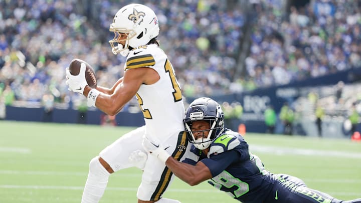 New Orleans Saints wide receiver Chris Olave catches a pass against Seattle Seahawks cornerback Josh Jobe.