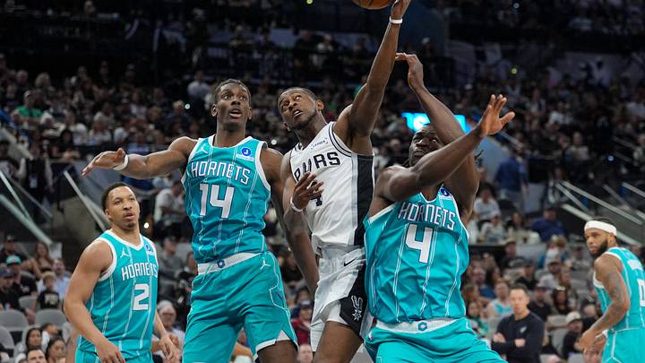 Mar 14, 2026; San Antonio, Texas, USA; San Antonio Spurs guard De'aaron Fox (4) shoots in between Charlotte Hornets forward Moussa Diabate (14) and guard Sion James (4) in the second half at Frost Bank Center. Mandatory Credit: Daniel Dunn-Imagn Images Mar 14, 2026; San Antonio, Texas, USA; San Antonio Spurs guard De'aaron Fox (4) shoots in between Charlotte Hornets forward Moussa Diabate (14) and guard Sion James (4) in the second half at Frost Bank Center. Mandatory Credit: Daniel Dunn-Imagn Images