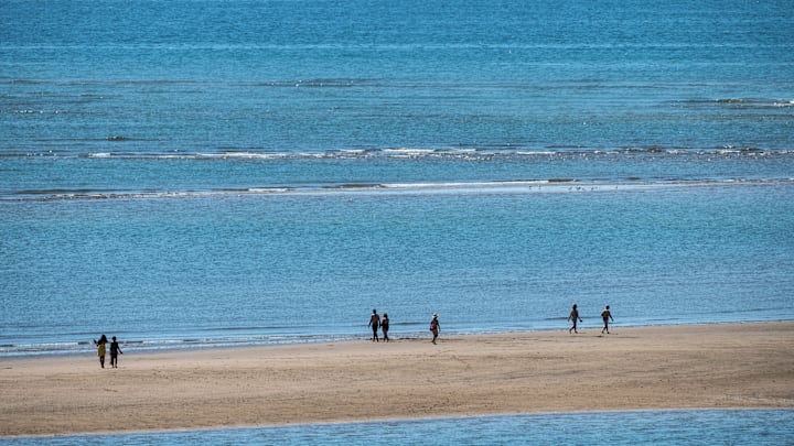 Tourists at the beach with low tide during a summer day at...
