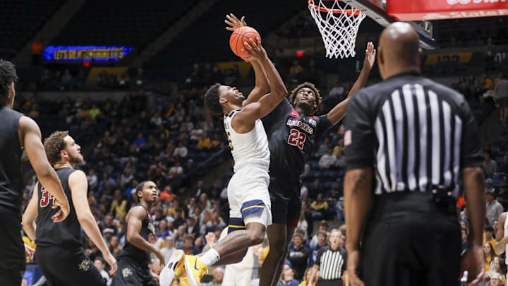 Nov 17, 2025; Morgantown, West Virginia, USA; West Virginia Mountaineers forward DJ Thomas (5) drives down the lane and shoots against Lafayette Leopards forward Christian Humphrey-Rembert (22) during the second half at WVU Coliseum. Mandatory Credit: Ben Queen-Imagn Images Nov 17, 2025; Morgantown, West Virginia, USA; West Virginia Mountaineers forward DJ Thomas (5) drives down the lane and shoots against Lafayette Leopards forward Christian Humphrey-Rembert (22) during the second half at WVU Coliseum. Mandatory Credit: Ben Queen-Imagn Images