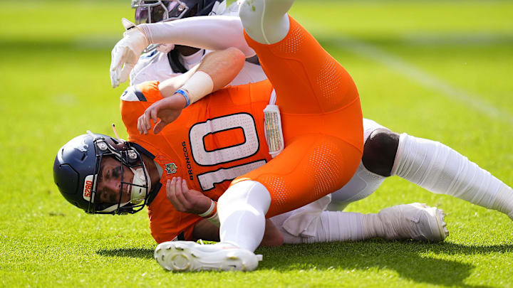 Sep 7, 2025; Denver, Colorado, USA; Denver Broncos quarterback Bo Nix (10) is knocked to the ground against the Tennessee Titans in the second half at Empower Field at Mile High. Sep 7, 2025; Denver, Colorado, USA; Denver Broncos quarterback Bo Nix (10) is knocked to the ground against the Tennessee Titans in the second half at Empower Field at Mile High.