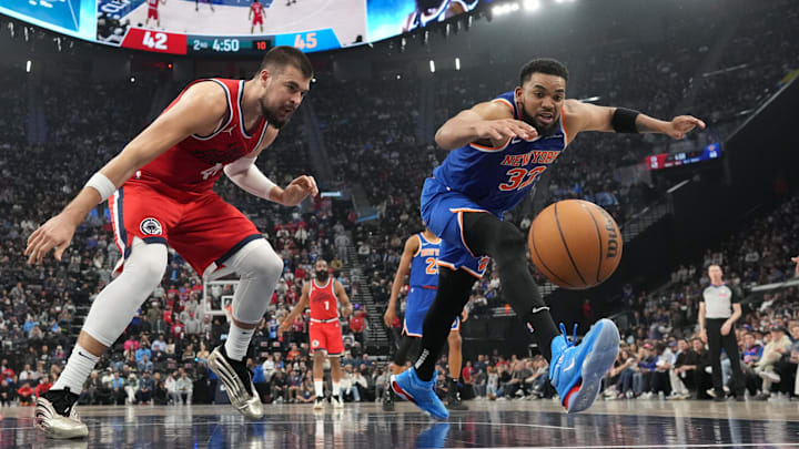 Mar 7, 2025; Inglewood, California, USA; New York Knicks center Karl-Anthony Towns (32) and LA Clippers center Ivica Zubac (40) reach for the ball in the first half at Intuit Dome. Mandatory Credit: Kirby Lee-Imagn Images