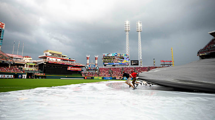 Cincinnati Reds grounds crew pulls off the tarp in before the MLB baseball game between the