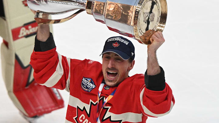 Team Canada forward Brad Marchand lifts the 4 Nations Face-Off trophy after winning against Team USA in overtime.