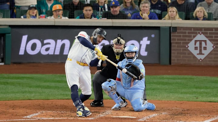 Oct 17, 2025; Seattle, Washington, USA; Seattle Mariners first baseman Josh Naylor (12) hits a single against the Toronto Blue Jays in the fourth inning during game five of the ALCS round for the 2025 MLB playoffs at T-Mobile Park. Mandatory Credit: John Froschauer-Imagn Images
