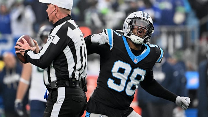Dec 28, 2025; Charlotte, North Carolina, USA; Carolina Panthers linebacker D.J. Wonnum (98) tosses the ball to referee Carl Cheffers (51) and reacts after sacking Seattle Seahawks quarterback Sam Darnold (not pictured) during the fourth quarter at Bank of America Stadium. Mandatory Credit: Bob Donnan-Imagn Images