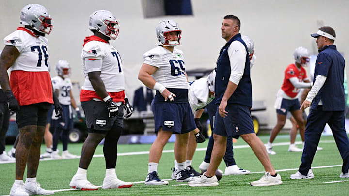Jun 10, 2025; Foxborough, MA, USA; New England Patriots head coach Mike Vrabel (center) and offensive coordinator Josh McDaniels (r) work with center Garrett Bradbury (65), offensive tackle Mike Onwenu (71) and offensive tackle Morgan Moses (76) during minicamp held in the WIN Field House at Gillette Stadium. Mandatory Credit: Eric Canha-Imagn Images