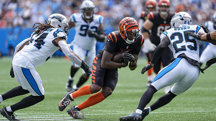 Sep 29, 2024; Charlotte, North Carolina, USA; Cincinnati Bengals wide receiver Tee Higgins (5) runs for yards after catch against Carolina Panthers linebacker Shaq Thompson (54) and safety Xavier Woods (25) during 1st quarter at Bank of America Stadium. Mandatory Credit: Jim Dedmon-Imagn Images Sep 29, 2024; Charlotte, North Carolina, USA; Cincinnati Bengals wide receiver Tee Higgins (5) runs for yards after catch against Carolina Panthers linebacker Shaq Thompson (54) and safety Xavier Woods (25) during 1st quarter at Bank of America Stadium. Mandatory Credit: Jim Dedmon-Imagn Images