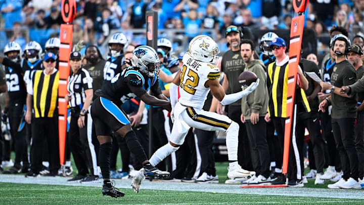 Nov 9, 2025; Charlotte, North Carolina, USA; New Orleans Saints wide receiver Chris Olave (12) makes a one handed catch as Carolina Panthers cornerback Chau Smith-Wade (26) defends during the fourth quarter at Bank of America Stadium. Mandatory Credit: Bob Donnan-Imagn Images Nov 9, 2025; Charlotte, North Carolina, USA; New Orleans Saints wide receiver Chris Olave (12) makes a one handed catch as Carolina Panthers cornerback Chau Smith-Wade (26) defends during the fourth quarter at Bank of America Stadium. Mandatory Credit: Bob Donnan-Imagn Images