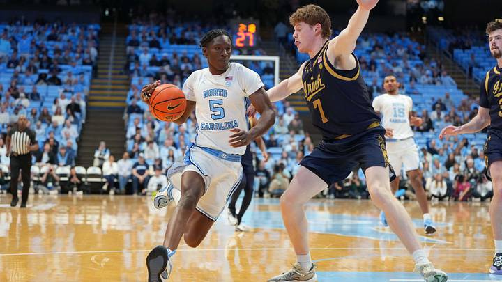 Jan 21, 2026; Chapel Hill, North Carolina, USA; North Carolina Tar Heels guard Isaiah Denis (5) with the ball as Notre Dame Fighting Irish forward Ryder Frost (7) defends in the second half at Dean E. Smith Center. Mandatory Credit: Bob Donnan-Imagn Images