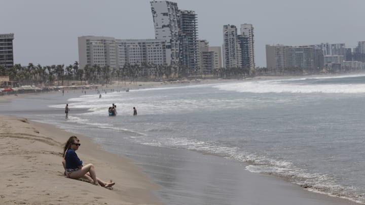 Tourist enjoy the beach as Hotels look destroyed at Riviera...