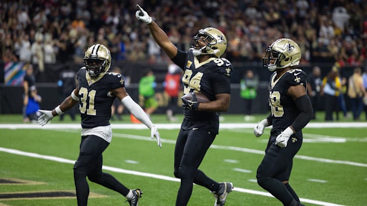 Oct 13, 2024; New Orleans, Louisiana, USA;  New Orleans Saints defensive end Cameron Jordan (94) reacts to intercepting the pass of Tampa Bay Buccaneers quarterback Baker Mayfield (6) during the first half at Caesars Superdome. Mandatory Credit: Stephen Lew-Imagn Images