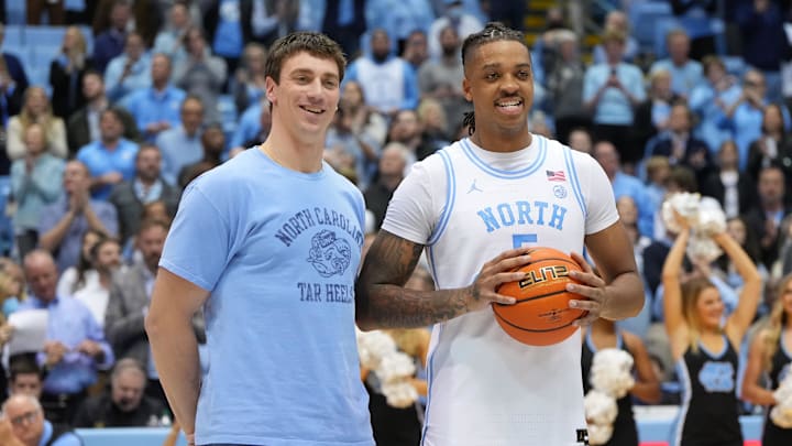 Jan 21, 2023; Chapel Hill, North Carolina, USA; Former North Carolina Tar Heels great Tyler Hansbrough presents forward Armando Bacot (5) with the game ball after the game. Bacot became the all-time Tar Heels rebounding leader during the game breaking Hansbrough   s record. Mandatory Credit: Bob Donnan-Imagn Images
