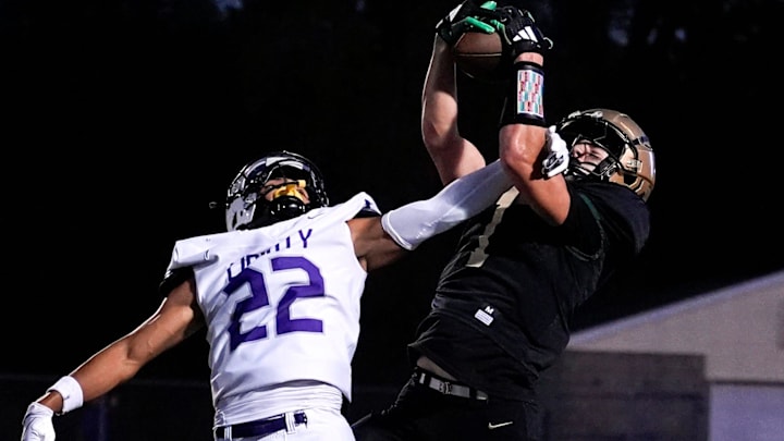 Iowa City West’s Ethan Headings (1) makes a catch contested by Liberty’s Adrian Clerry (22) during a high school football game Sept. 26, 2025 at Iowa City West in Iowa City, Iowa.